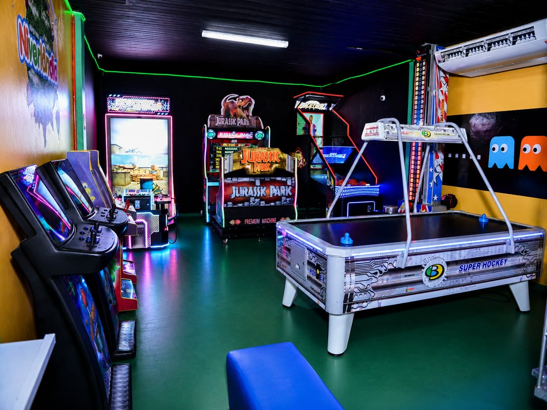 Área Teen do Niverlândia com air hockey, fliperamas e simuladores